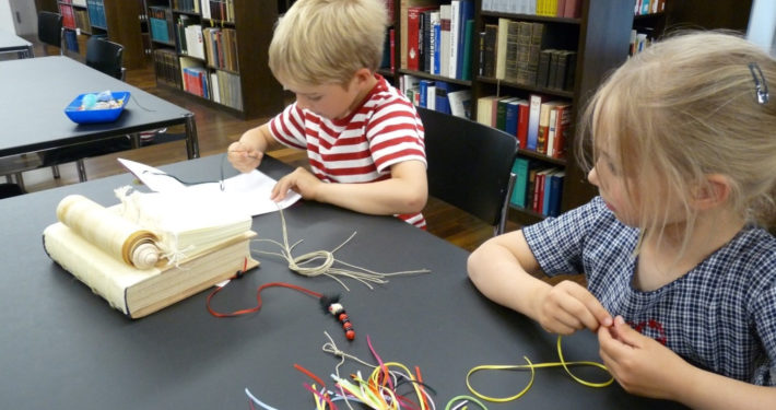 Zwei Kinder beim Bücher binden im Stiftsmuseum Xanten